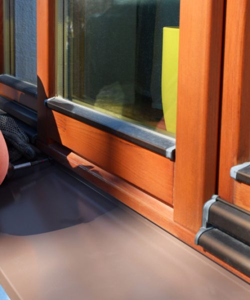 Man,Worker,Installing,Sill,On,External,Wooden,Window,Frame,On