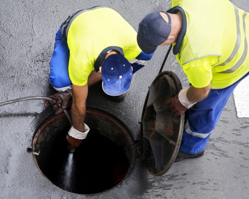 Sewerage,Workers,Draining,The,Sewer,Line